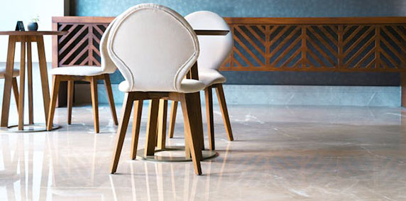 A polished marble floor featuring a stylish bar and several chairs arranged around it.