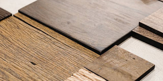 Assorted wooden planks of varying textures and brown tones arranged on a flat surface.