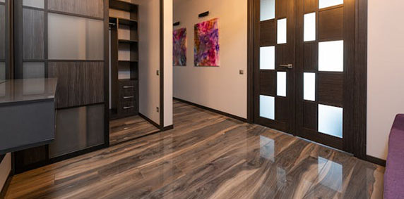 A hallway featuring wooden floors and a vibrant purple couch against the wall.